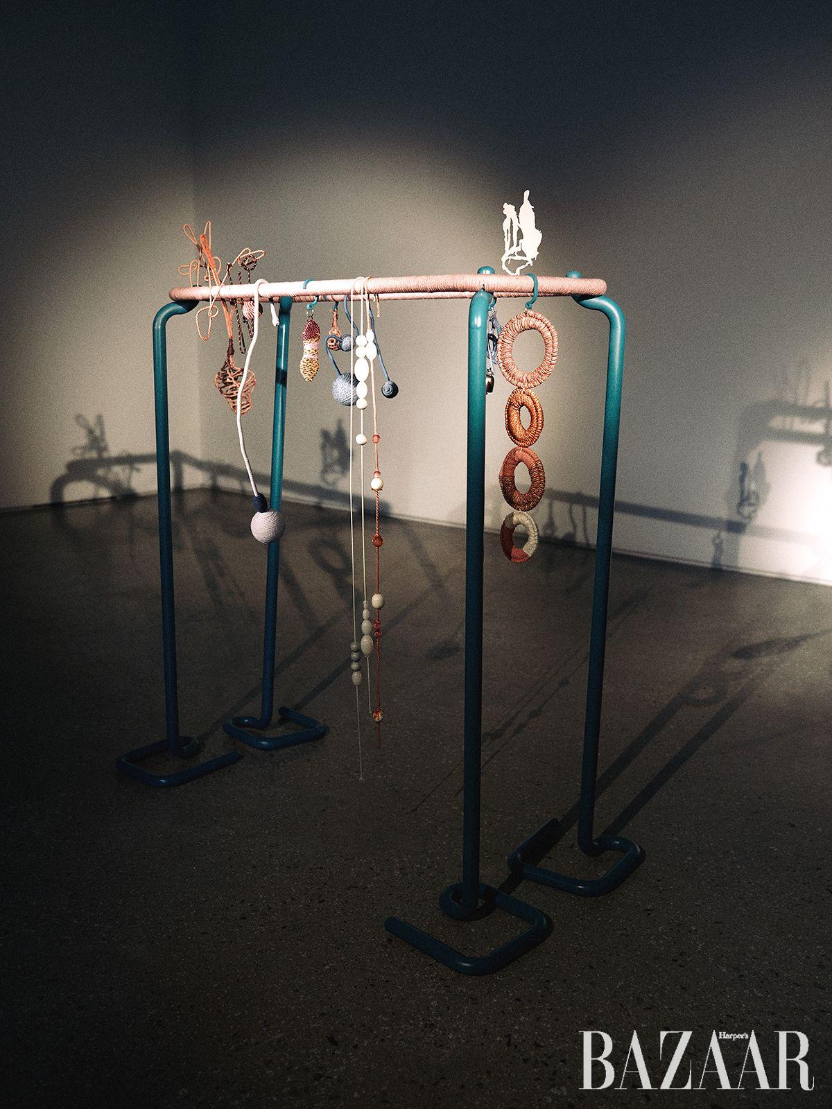 <Composition Game>, 2025, Stainless steel (pipes, and a small flat sculpture), textile strings, beads, bells, and stainless steel wire, 116x113x50cm. Courtesy of the artist and PKM Gallery.