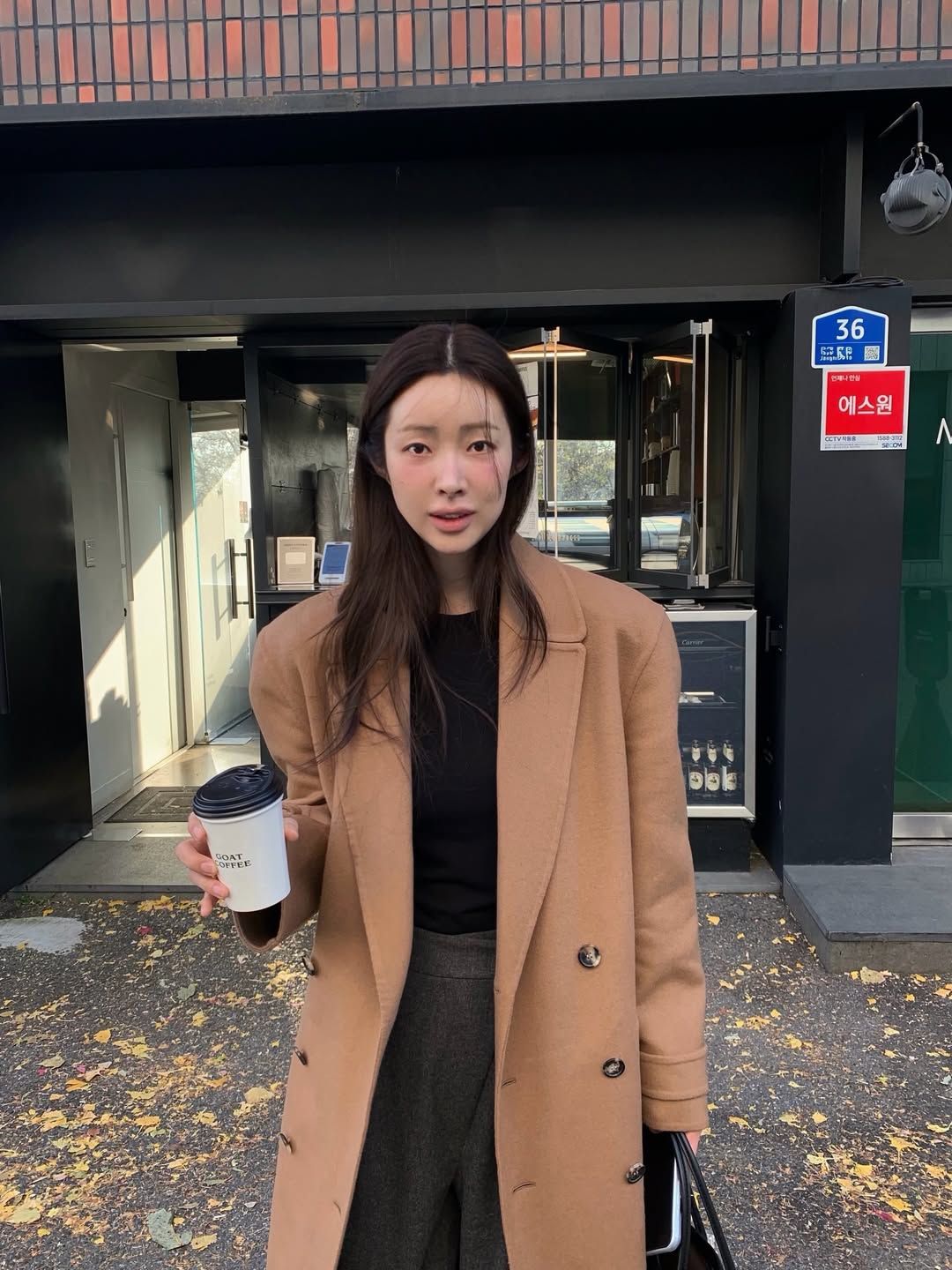 블랙 니트 탑과 다크 그레이 팬츠에 카멜 코트를 매치해 클래식한 룩을 완성한 차정원 / @ch_amii