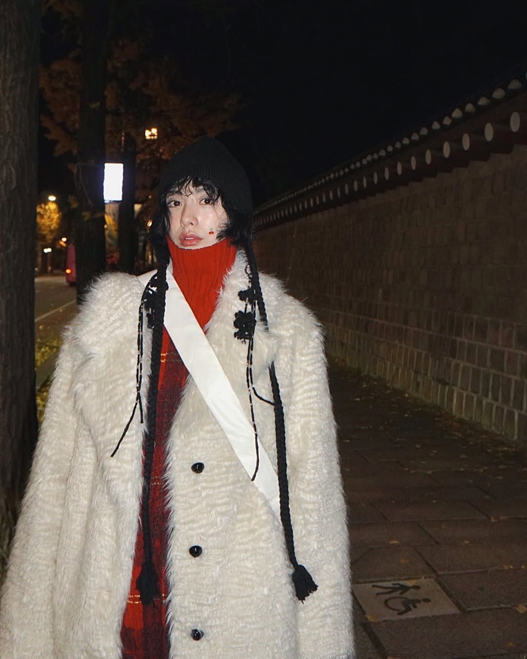 화이트 퍼 코트에 레드 컬러 터틀넥과 유니크한 디테일의 블랙 비니로 완성한 나나의 감각적인 컬러 매칭 @jin_a_nana