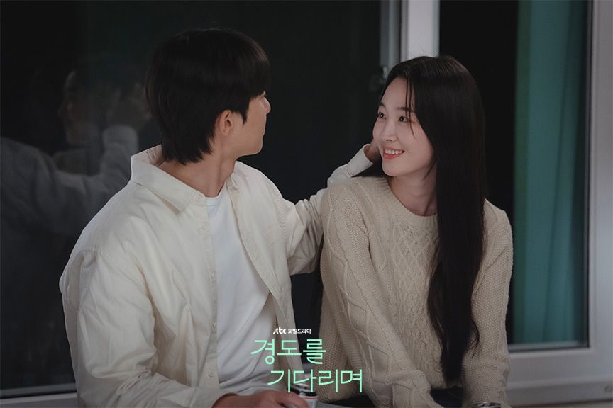 오트밀 컬러의 케이블 니트를 입은 지우