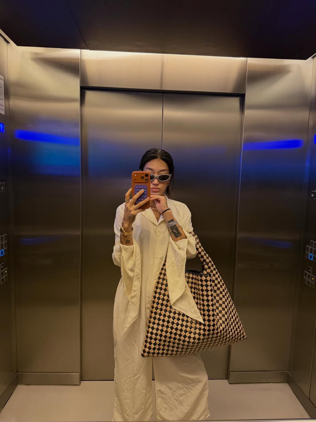 화이트 점프 수트에 위빙 빅 백을 들어 유니크한 포인트를 더한 페기 구 / @peggygou_