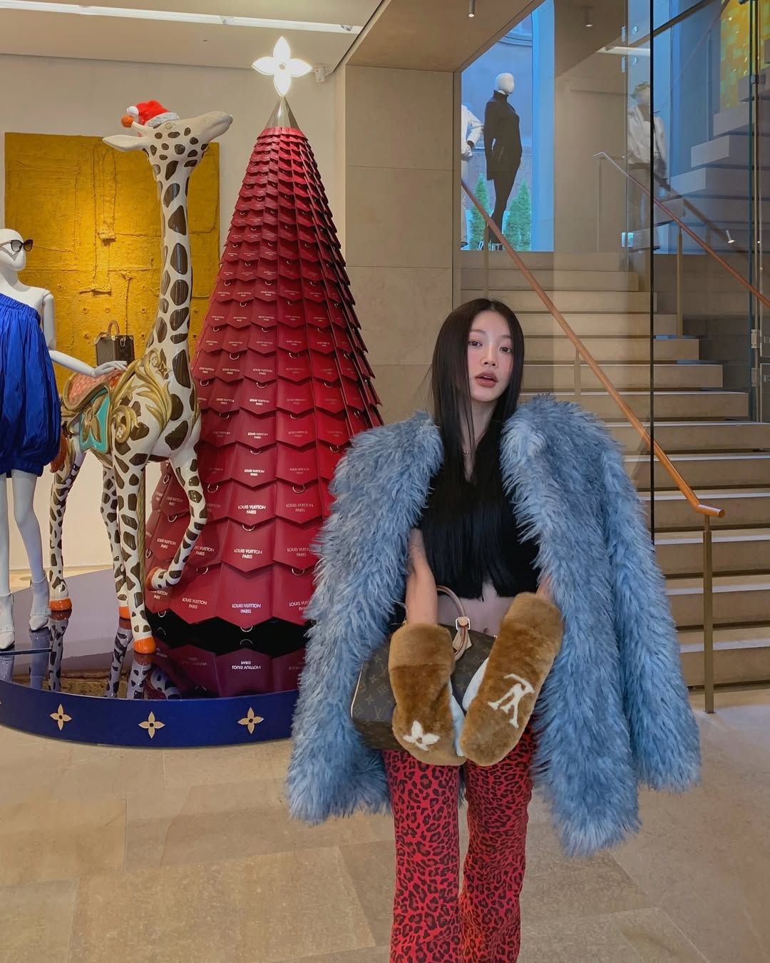 블루 컬러의 퍼 아우터에 레드 레어퍼드 팬츠를 매치해 유니크한 스타일링을 선보인 설쁘 / @mulbada