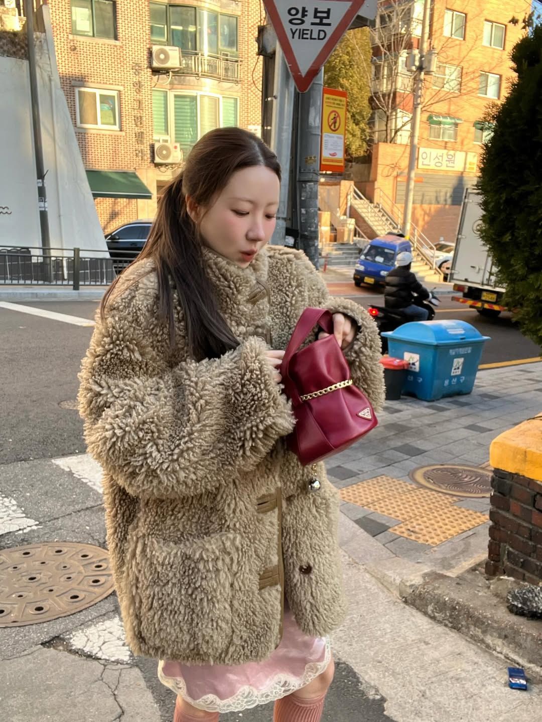 퍼 코트, 핑크 컬러 슬립 드레스와 함께 와인 빛의 프라다 미니 백을 매치해 감각적인 룩을 완성한 오눅 / @onnuk_