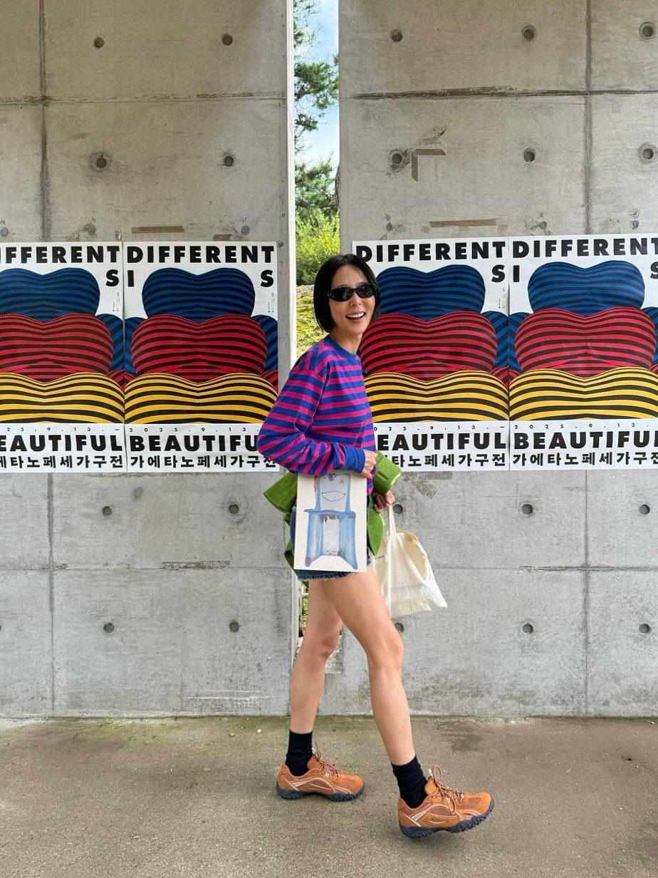 유니크한 스트라이프 톱과 데님 쇼츠, 오렌지 컬러의 스니커즈를 착용해 경쾌한 분위기를 연출한 김나영 / @nayoungkeem