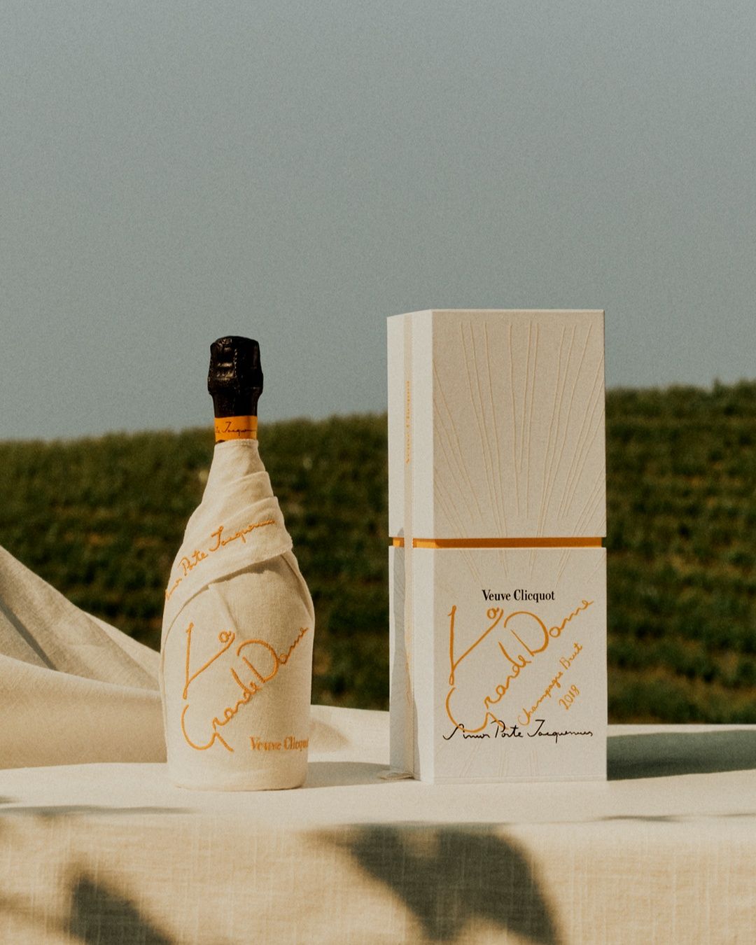 화이트 린넨 소재에 노란 자수가 놓여진 라벨