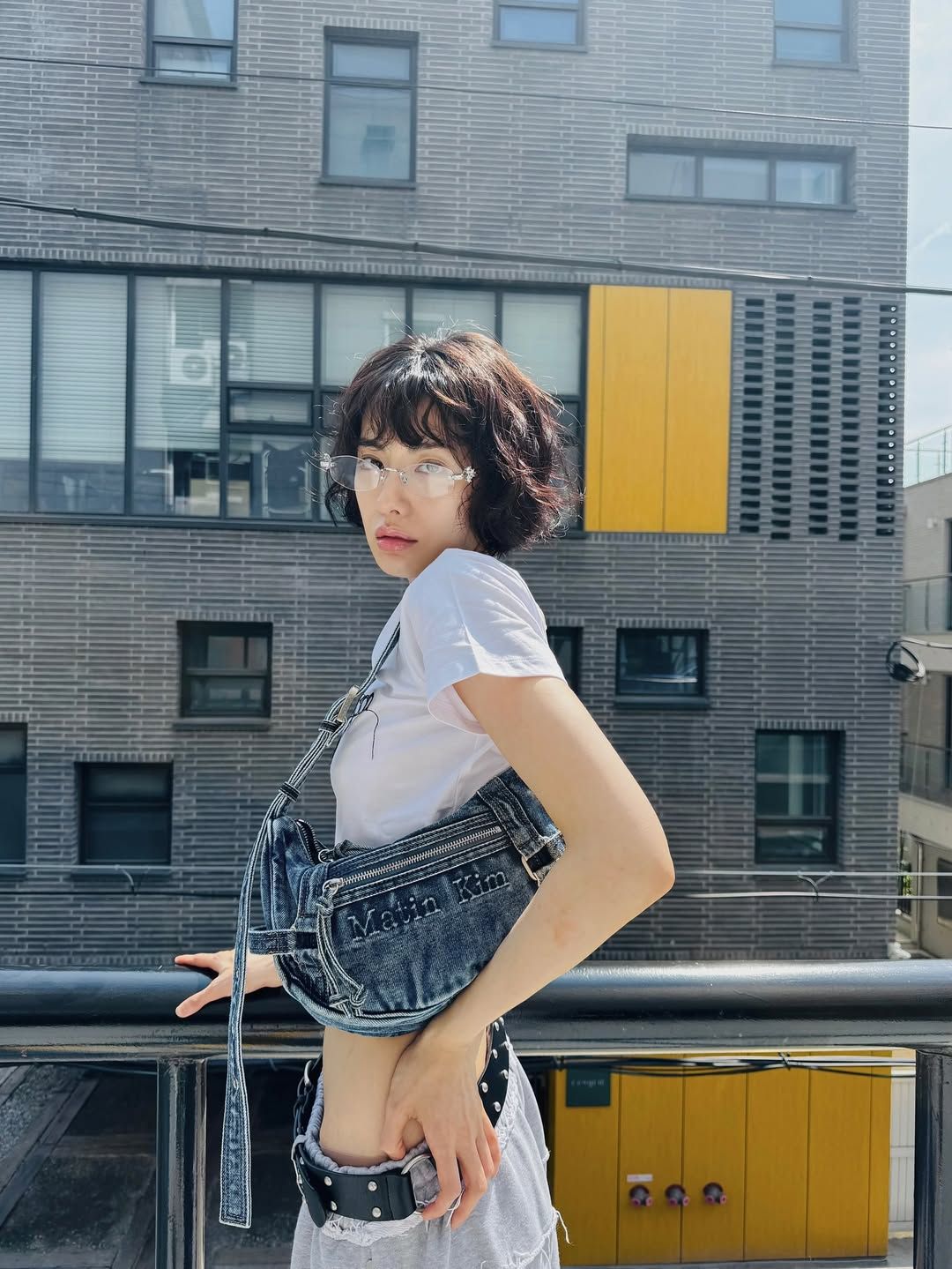 화이트 크롭 티셔츠, 데님 호보백과 함께 무테 안경을 매치해 청량한 에너지를 선보인 나나 / @jin_a_nana