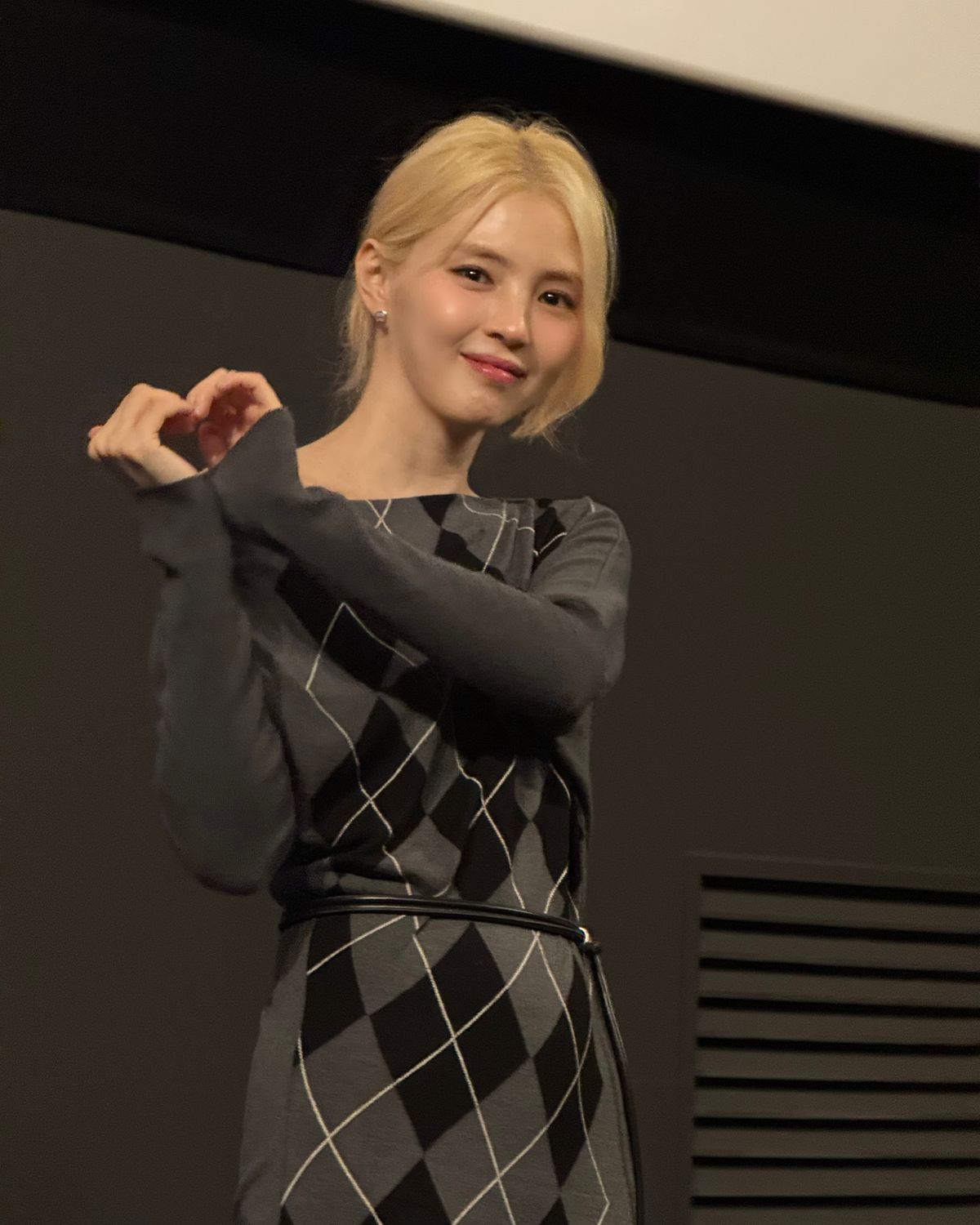 오버듀플레어의 아가일 니트로 비대칭 실루엣을 강조한 무대인사 패션.