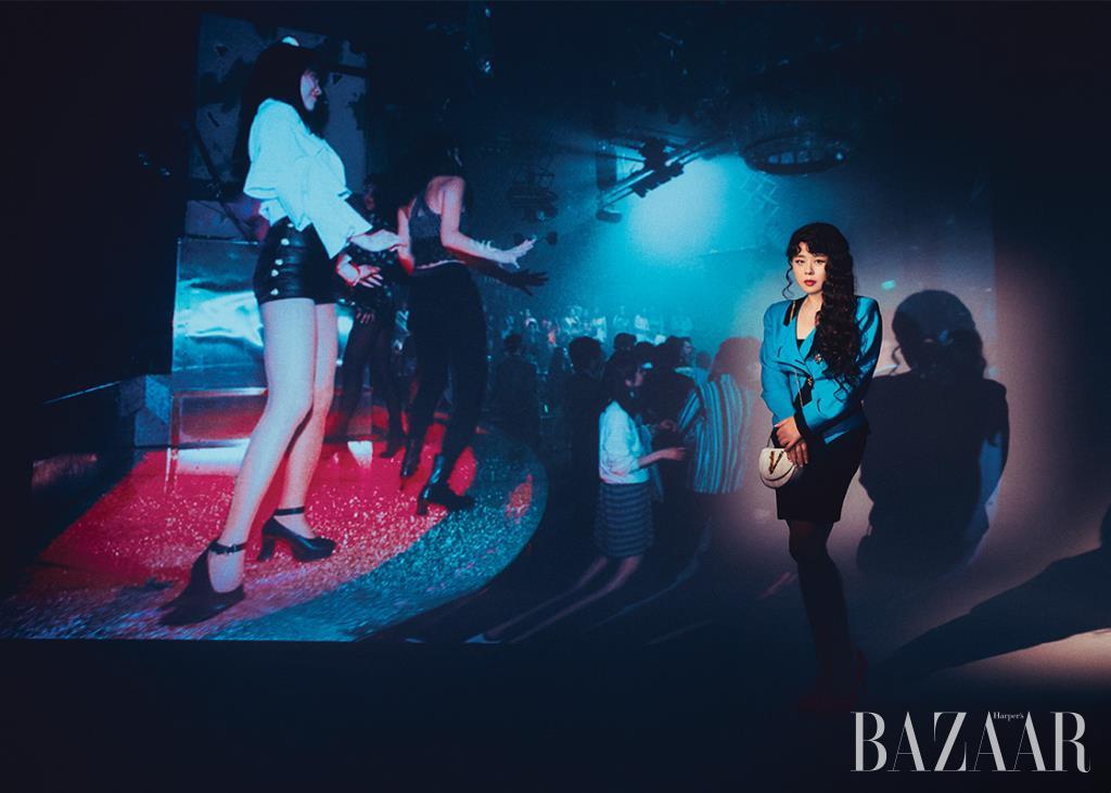 재킷은 Bell & Nouveau. 미니 드레스는 Cos. 골드 장식의 체인 백은 Versace. 스틸레토 펌프스는 Roser Vivier.